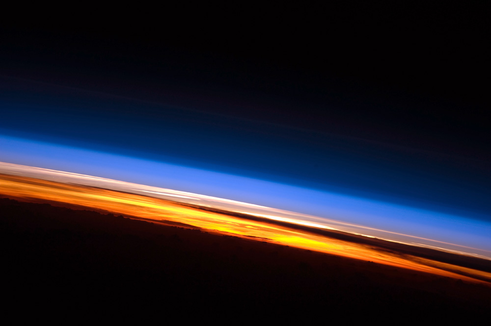The thin blue line of Earth's atmosphere at sunrise, photographed from the International Space Station